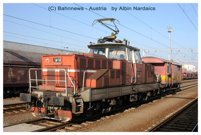 Bei der Abgebildeten E- Lok 210.069 handelt es sich um eine von etwa 10 Exemplaren die mit einem Batteriewagen nachgerüsteten E - Loks ( der rote G-Wagen im Bild ) der Sinn und Zweck, um auch in den Anschlussbahnen ohne Fahrleitungen fahren zu können (jed