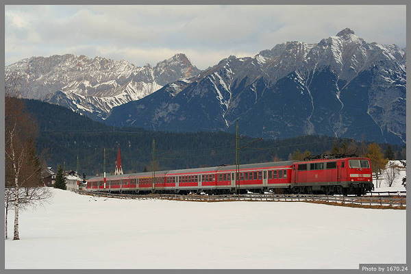 Vor der prächtigen Kulisse des Wetterseingebirges schiebt die 111 033 den Regionalzug 5408 in Richtung München Hbf.